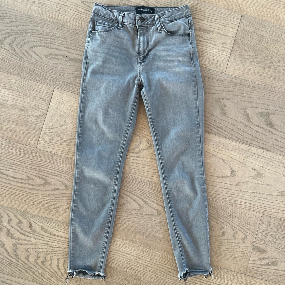 Grey-washed denim skinny jeans with frayed cut at ankles